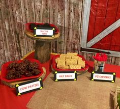 a table topped with red trays filled with cookies and crackers next to a sign that says cow patties