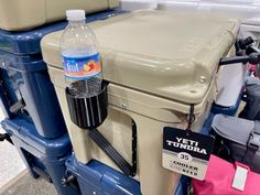 there are many coolers with water bottles on them in the store, including one for sale