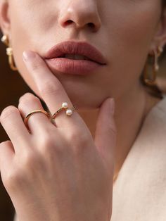 a close up of a person with a ring on their finger and her hand near her face