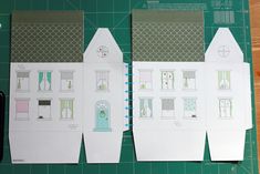 cut out paper houses sitting on top of a cutting board