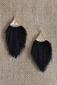 two pairs of black and white fringe earrings with pearls on top of each earring