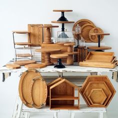 a table topped with lots of wooden plates and trays on top of each other