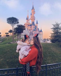 a woman holding a baby in front of a castle at sunset with the caption instagram