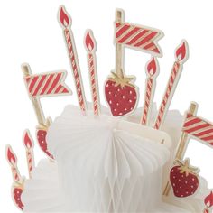 a cake with candles and strawberries on it is decorated in red, white and gold