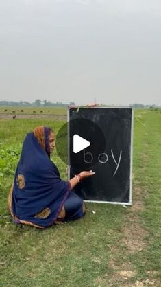 a woman kneeling down next to a blackboard with the word joy written on it