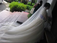 the bride is getting ready to walk down the stairs in her wedding dress and veil