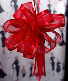 a red bow hanging from the side of a wall