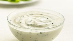 a bowl filled with white sauce sitting on top of a table