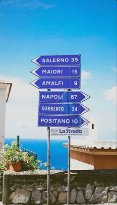 a blue street sign sitting on the side of a road