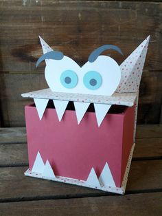 an origami box with a monster's mouth and tongue sticking out from it