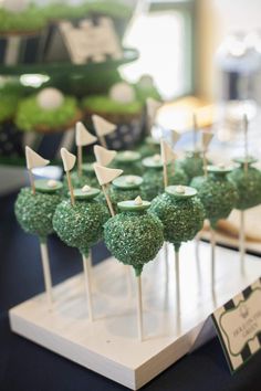 there are many green cake pops on the table