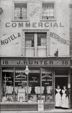 an old black and white photo of two women standing in front of a storefront