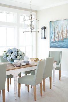 the dining room table is set with white chairs