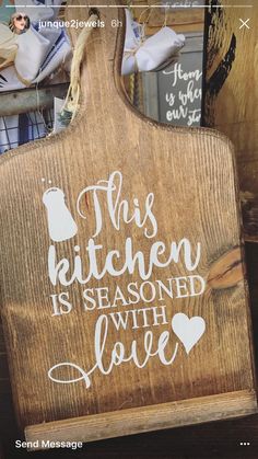 this kitchen is seasoned with love sign on a wooden board in front of other items