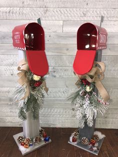 two mailboxs decorated with christmas decorations and pine cones are sitting on top of each other