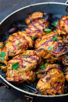 some chicken is cooking in a pan on the stove top with parsley and red wine