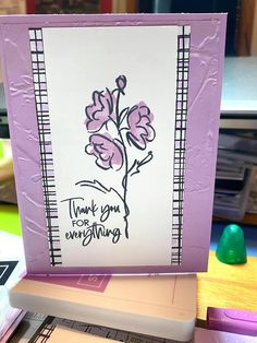 a card with flowers on it sitting on top of a table next to other cards