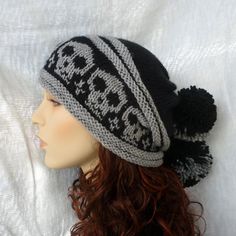 a black and white knitted hat with skulls on the front, sitting on top of a mannequin head