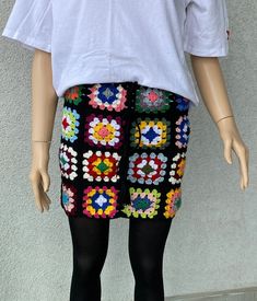 a mannequin is dressed in colorful crocheted shorts and tights with black stockings