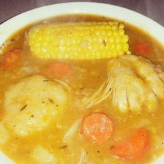 a white bowl filled with soup and corn on the cob