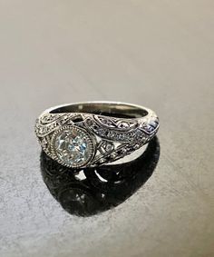 an antique style diamond ring with filigree accents