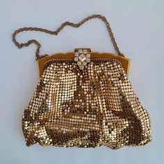 Whiting & Davis Mesh Bag Gold Tone with Rhinestone Clasp #2856 Small vintage evening bag An elegant W & D mesh bag, which I haven't been able to date, but likely 1950s. The purse is in good condition, with some signs of use. There are tiny scratches on the frame, and 2 very small pitted areas on the back, seen in photos. A couple of dark spots inside the frame. The interior fabric is clean, with no stains. Some threads which attach it  to the frame are slightly pulled. The purse snaps tightly shut. The mesh is shiny, with no dark areas. Approximate measure:  Frame width 3 3/4" Pouch 3 3/4" high without frame, 5 1/8" wide at bottom Chain 8 1/2" long Stamped with logo, Made in USA, and model # 2856 on both sides of the frame, plus the cloth W & D label. Returns gladly accepted with return po Vintage Gold Shoulder Bag For Party, Vintage Clutch Shoulder Bag For Party, Elegant Evening Bag For Vintage Events, Elegant Clutch Evening Bag For Vintage Events, Elegant Gold Sequined Bags, Elegant Gold Sequined Shoulder Bag, Elegant Gold Bags With Sequins, Gold Sequined Shoulder Bag For Evening, Vintage Embellished Wedding Shoulder Bag