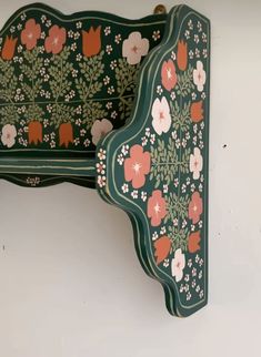 two green and red floral patterned trays hanging on the wall