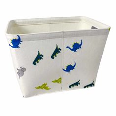 a white storage bin with blue and green dinosaur designs on it's sides, sitting against a white background