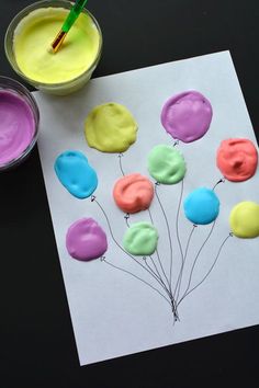 a paper with some balloons on it next to paint