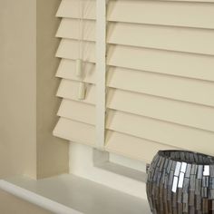 a black vase sitting on top of a window sill next to a white wall