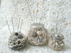 three small purses sitting on top of a white lace covered table next to each other