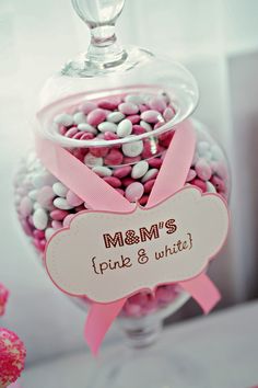 pink and white candies in a glass bowl with a name tag on the front