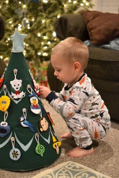 a baby playing with a christmas tree decoration