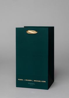 a green paper bag with a gold handle