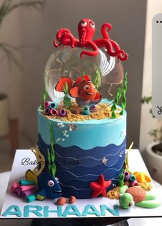 a birthday cake decorated with an ocean scene and under the sea animals in a fish bowl