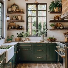 a kitchen filled with lots of green cabinets and counter top space next to a window