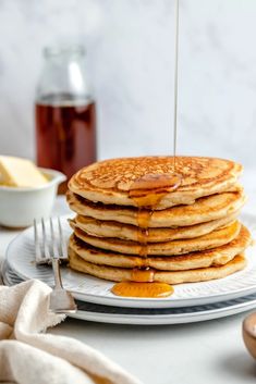 a stack of pancakes with syrup being drizzled on top