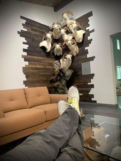 a person laying on the floor with their feet up in front of a wall sculpture