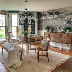 a dining room with a table and chairs in front of a painting on the wall