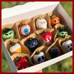 an open box filled with different types of candies in the shape of skulls and eyes