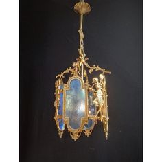 an ornate gold chandelier with blue glass and cherubs hanging from the ceiling