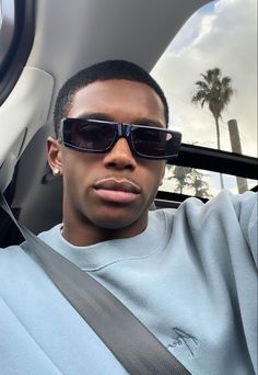 a man wearing sunglasses sitting in a car