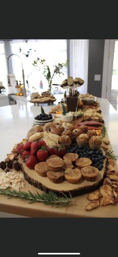 a table topped with lots of different types of food on top of a wooden cutting board