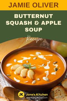 a bowl of butternut squash and apple soup with toasted bread on the side