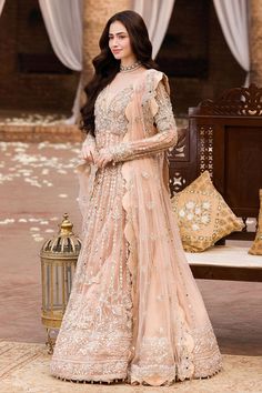 Pakistani Wedding Dress in Pishwas Frock Lehenga Style is an elegant attire that will give you a stunning look on the big day. Lavish designs and hand-crafted embellishments make this flawless Pakistani Bridal Outfit an epitome of beauty and your foremost priority to have a magical look. Pakistani Gown: Pakistani Gown in an alluring peach color is beautifully embellished with the intricate silverwork and embroideries. Shimmering ornaments, zardosi, swarovski, crystals, and pearls give a glamorou Floor-length Wedding Dress For Eid Reception, Anarkali Wedding Dress With Resham Embroidery For Party, Designer Wedding Dress With Resham Embroidery For Eid, Anarkali Dress With Pallu For Wedding, Designer Anarkali Wedding Dress With Traditional Drape, Bollywood Style Organza Wedding Dress With Dabka Work, Anarkali Floor-length Wedding Dress, Semi-stitched Dabka Work Wedding Gown, Floor-length Anarkali Wedding Dress