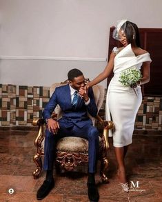 a man in a suit and tie sitting on a chair next to a woman in a white dress