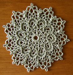 a crocheted doily sitting on top of a wooden table