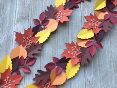 paper leaves are arranged on a wooden surface