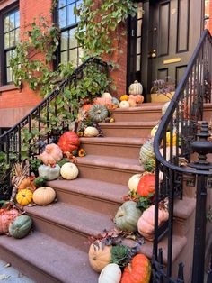 pumpkins and gourds on the steps of a house