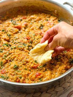 a person is dipping some bread into a pot of food that has been cooked in it